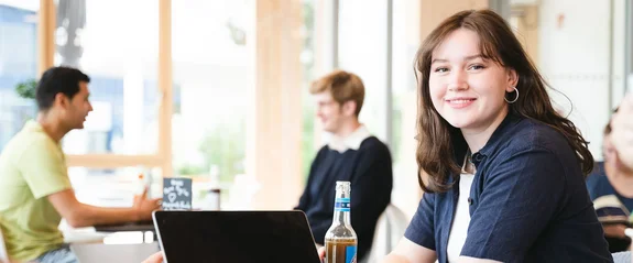Studentin in PPE (M. A.) an der UW/H sitzt im Lernflur.