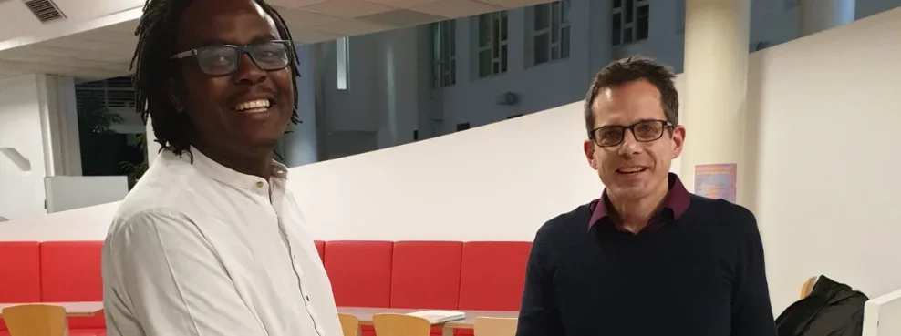 Zwei Personen lächeln in die Kamera.