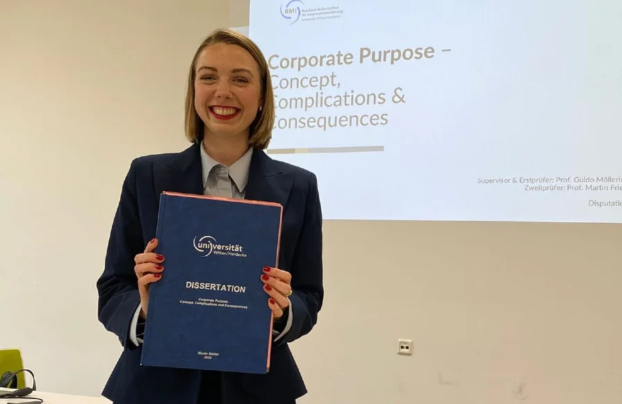 Nicole Steller hält ihre Dissertation in der Hand, die sie gerade erfolgreich verteidigt hat (Foto vom RMI)