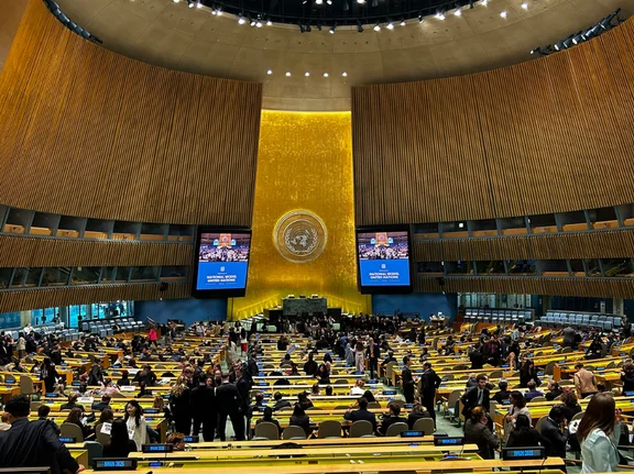 Innenaufnahme eines großen Konferenzsaals mit vielen Stuhlreihen und hohen Decken.