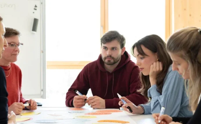 Professorin und Studierende sitzen an einem Tisch zum Dialog