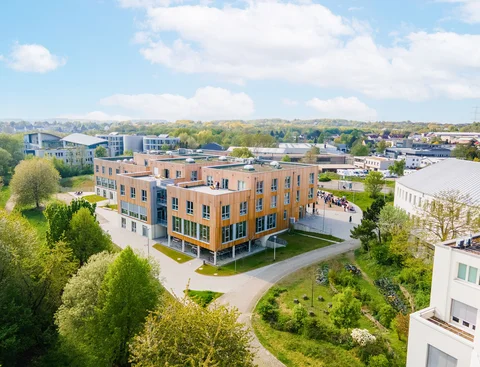 Wooden building of the UW/H (Photo: UW/H | Johannes Buldmann) Drone image of the wooden building of the UW/H