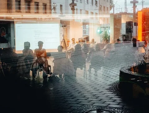 Foto durch eine verspiegelte Fensterscheibe auf eine Seminargruppe 
