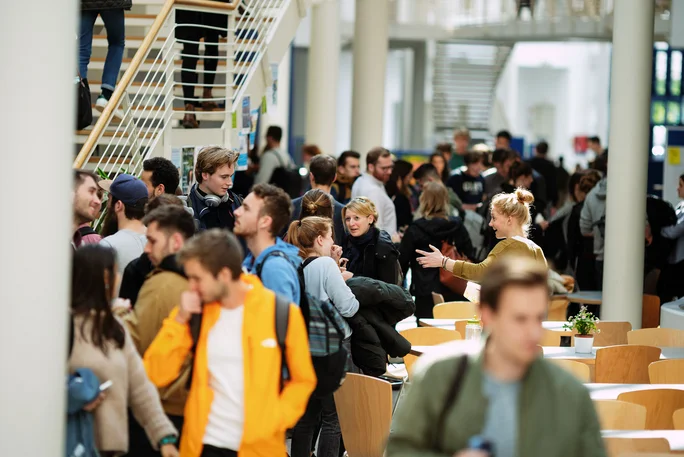 Foto von zahlreichen Studierenden, die durch die Campushalle laufen.