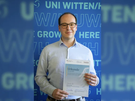 Das Deutschlandstipendium ermöglicht es Tim Schröder Studium und Ehrenamt miteinander zu verbinden. (Foto: UW/H | Miriam Kreimeyer) Porträt von Tim Schröder mit der Urkunde des Deutschlandstipendiums.