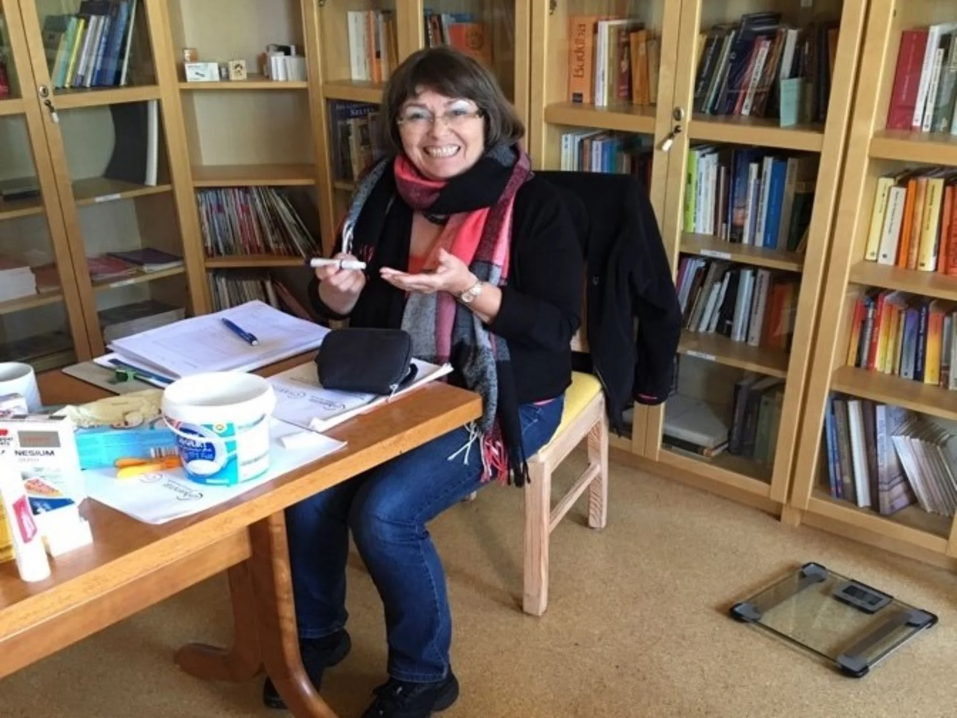 A woman takes a blood glucose measurement on her finger.