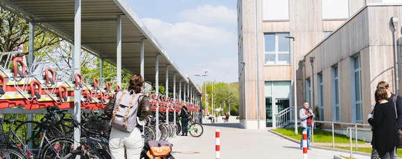 Bicycle car park at the UW/H (Photo: UW/H | Johannes Buldmann) Bicycle car park at the new UW/H building. In the foreground is a woman, with her back to the camera, standing in front of her bicycle.