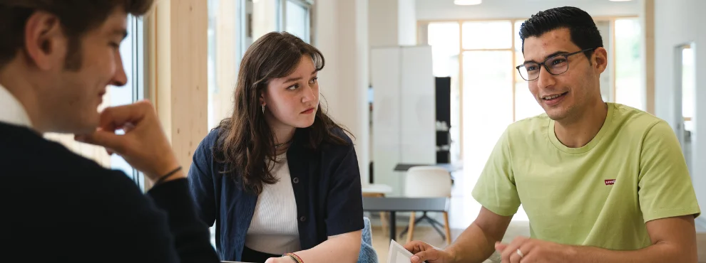 Three students in conversation in the new building