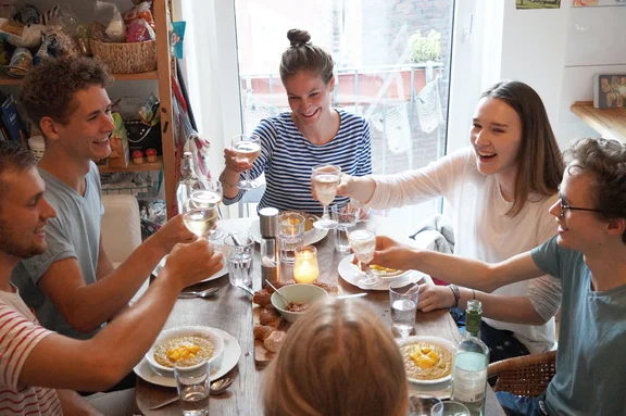 That flat-share vibe (Photo: Private) A group of students are sitting together at the dining table having dinner and clinking their glasses.