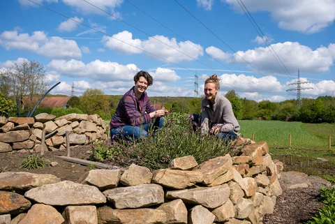 Zwei Wochen arbeiten auf dem Uni-eigenen Gemüse-Acker. Im Vordergrund ist eine gemauerte Kräuterspirale zu sehen.