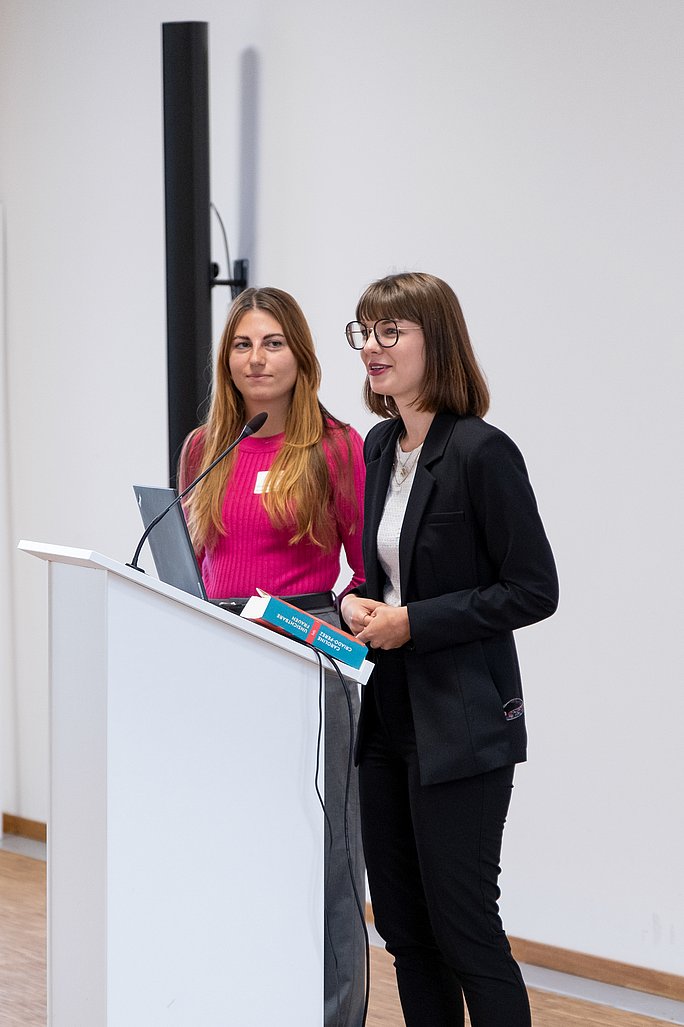 The Summer School was organised by Manuela Malek and Prof. Dr Theresa Sophie Busse, Junior Professor of Digital Health, among others. (Photo: UW/H | Klara Schmickler) Two people are standing at a lectern with a microphone.