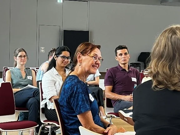 Expert:innen, Nachwuchswissenschaftler:innen und Praxispartner:innen sitzen in einem Seminarraum.