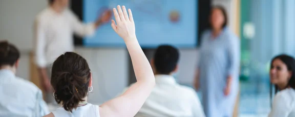 Die Uni kommt ins Klassenzimmer. (Foto: UW/H | JohannesBuldmann) Seminarsituation: Junge Personen sitzen im Vordergrund an Tischen und im Hintergrund stehen Lehrpersonen an einer digitalen Tafel.