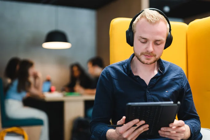Ein Studierender lernt konzentriert mit Tablet und Kopfhörern in einem der Lernräume