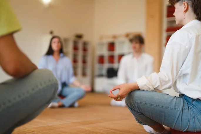 Ausgleich im Yogakurs (Foto: UW/H | Johannes Buldmann) Studierende sitzen auf dem Fußboden im Yogakurs.