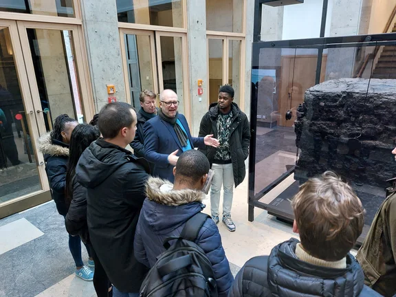 Dr. Michael Farrenkopf steht vor einer Gruppe Studierender und spricht