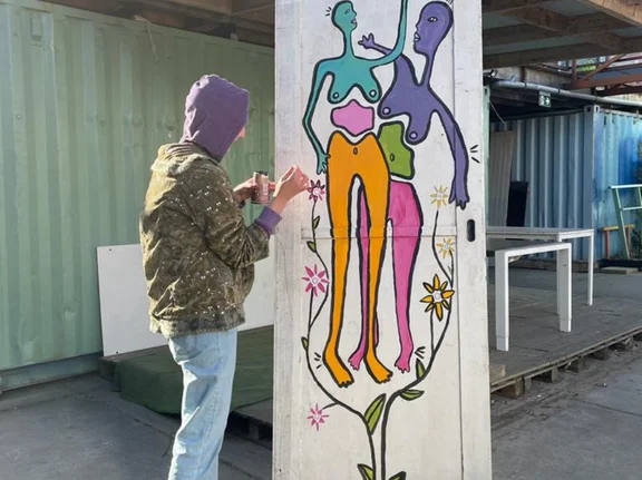 Art is an important source of balance for Ia. At the same time, she believes it can help bring people together. (Photo: Private) Ia has her back to the camera; she is holding paints and a brush and is painting a stele.