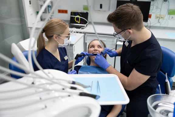 At the UW/H, trainees to become dental assistants familiarise themselves with many specialist areas. (Photo: UW/H | Michael Schwettmann) Two dental assistants work on a patient.