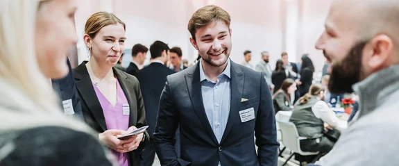 Foto von vier Personen in einer Gesprächssituation.