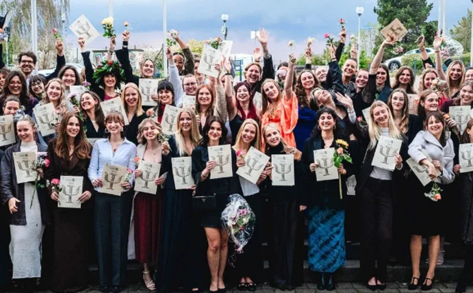 Mehr als 100 Bachelor- und Masterabsolvent:innen der Universität Witten/Herdecke feierten ihren erfolgreichen Studienabschluss. (Foto: Grubenglück) Gruppenbild von feiernden Absolvent:innen, die ihre Zeugnisse hochhalten.
