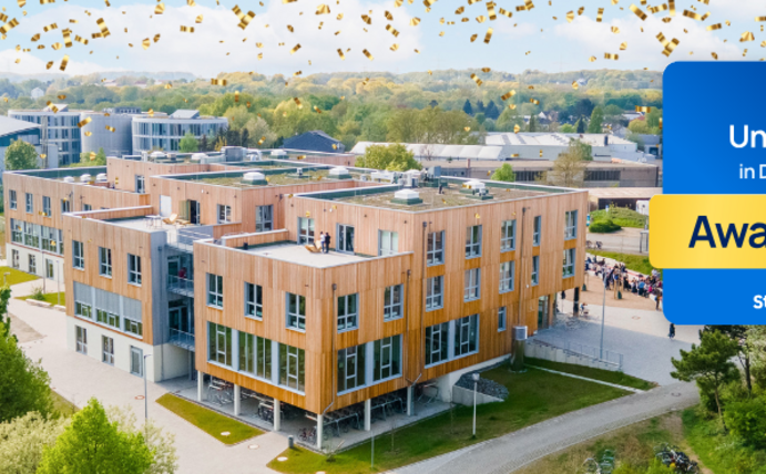 Photo of the wooden building on the UW/H campus. In the foreground is the StudyCheck seal.