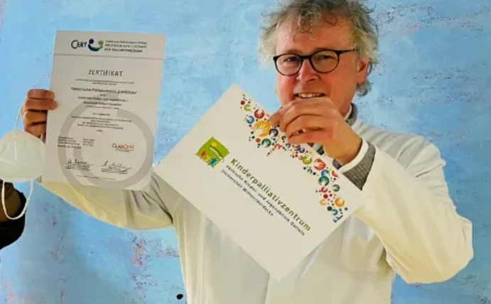 Fünf Personen stehen schräg hintereinander und halten die Urkunde und Zettel in die Höhe, auf denen Zertifizierung zu lesen ist.