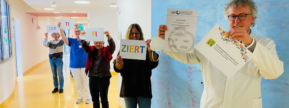  Five people stand diagonally behind each other and hold up the certificate and slips of paper on which certification can be read.