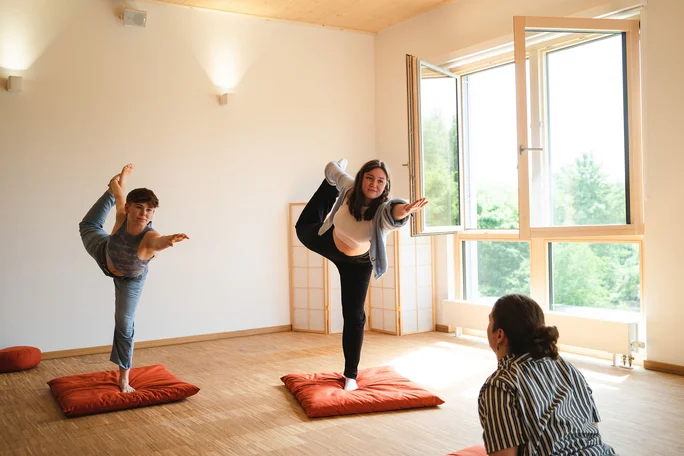 Study-life balance through sports programmes (Photo: UW/H | Johannes Buldmann) Students meet in the relaxation room at UW/H to practise yoga together. The two students in the picture are in the "dancer" yoga pose.