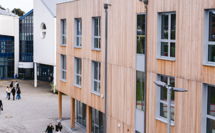 Zwei Gebäude der UW/H. Im Vordergrund der Neubau, im Hintergrund das Hauptgebäude.