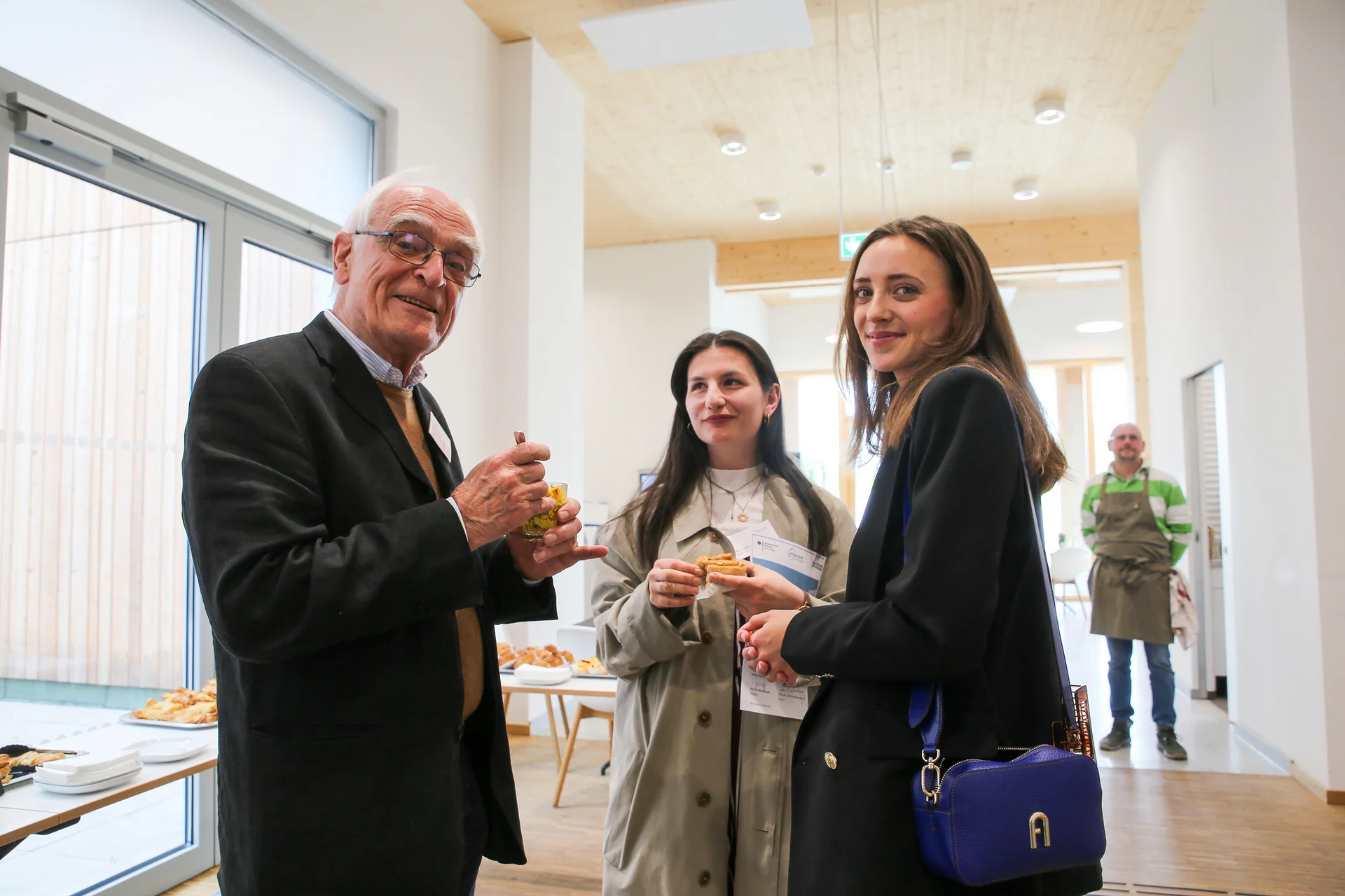 Two scholarship holders and a donor in conversation.