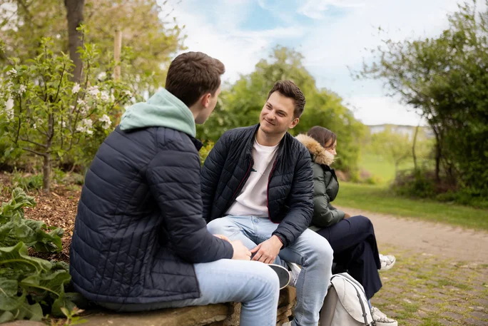 Two students chatting in the university garden