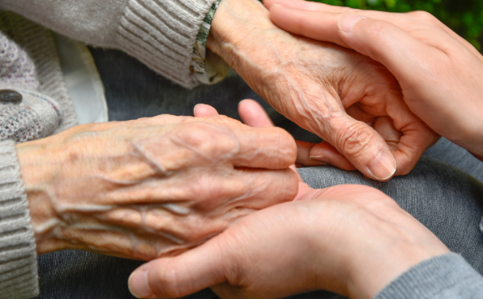 Das Forschungsprojekt ParGenDA nimmt Geschlechterunterschiede bei Demenz in den Blick. (Foto: Canva) Die Hände einer alten Frau liegen in den Händen einer jungen Frau.