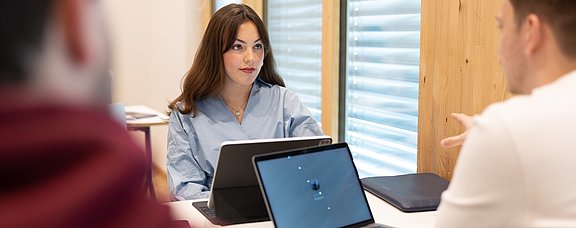 In Pflegewissenschaft Promovierende arbeiten mit ihren Laptops in einem Lernbereich der UW/H