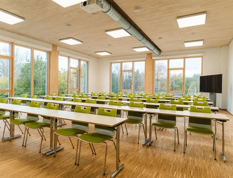 Foto eines Seminarraums mit Tisch- und Stuhlreihen