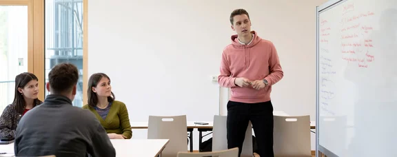 Students of anthroposophic medicine discuss a case on the whiteboard 