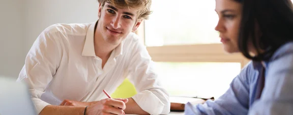 Bewirb dich für den Studiengang Wirtschaft, Politik und Recht (B. A.) an der UW/H. (Foto: UW/H | Johannes Buldmann) Ein junger Mann und eine junge Frau sitzen mit einem Laptop an einem Tisch.
