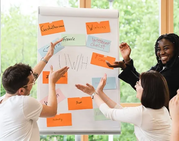 Unser Vibe an der UW/H (Foto: UW/H | Johannes Buldmann) Studierende mit Flipchart beschreiben den Vibe an der UW/H.