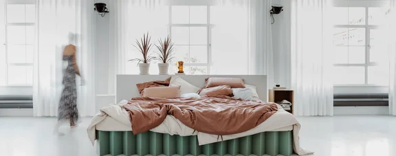 Foto eines Bettes aus Wellpappe in einem hell eingerichteten Raum.