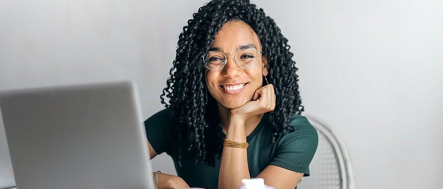 In unseren Online-Schnupperseminaren bekommen Studieninteressierte einen Einblick in das Psychologie-Studium an der UW/H. (Foto: pexels | Andrea Piacquadio) Eine junge Frau sitzt vor einem Laptop und lächelt in die Kamera.