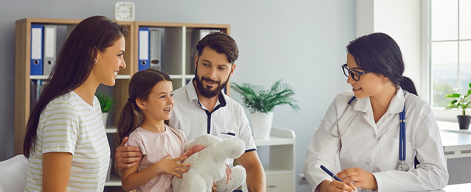The INITIAL study investigates the connection between the timing of vaccinations and children's health (Photo: Canva) Parents and child visiting the doctor in the treatment room
