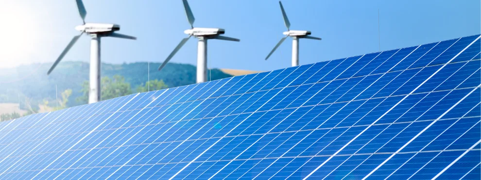 Solapanels can be seen in the foreground and three wind turbines in the background.