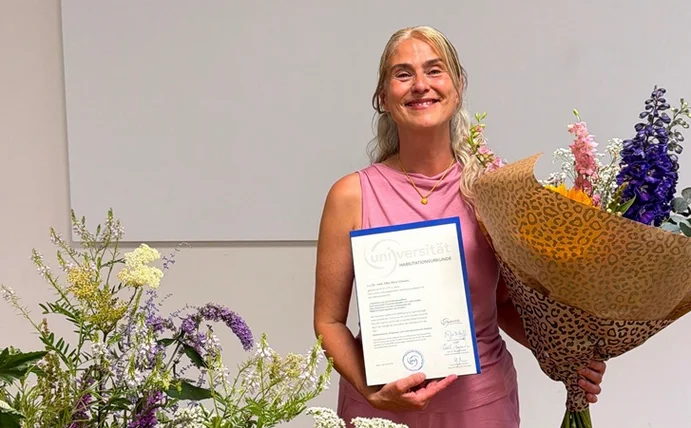 PD Dr. med. Silke Schwarz mit ihrer Habilitationsurkunde der Universität Witten/Herdecke (Foto: UW/H) PD Dr. med. Silke Schwarz mit ihrer Urkunde und einem Blumenstrauß in der Hand auf der Bühne