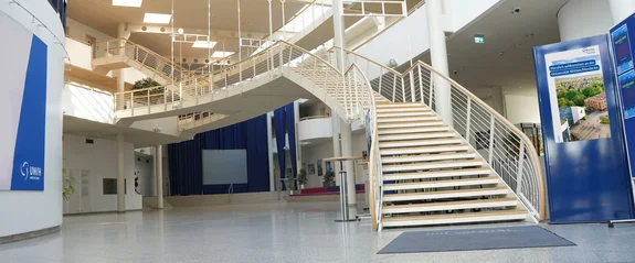 Foto einer weitläufigen Halle mit Treppen, die nach oben führen.