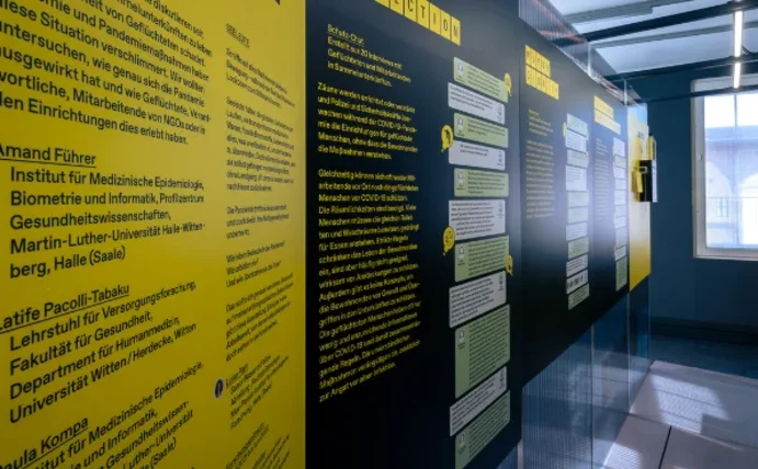 Gelbe und schwarze Ausstellungstafeln stehen in einem Raum.