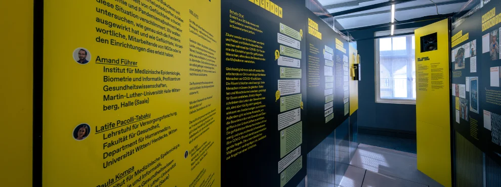 Gelbe und schwarze Ausstellungstafeln stehen in einem Raum.
