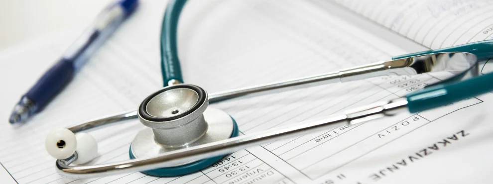 Stetoscope and ballpoint pen lie on a sheet of paper.