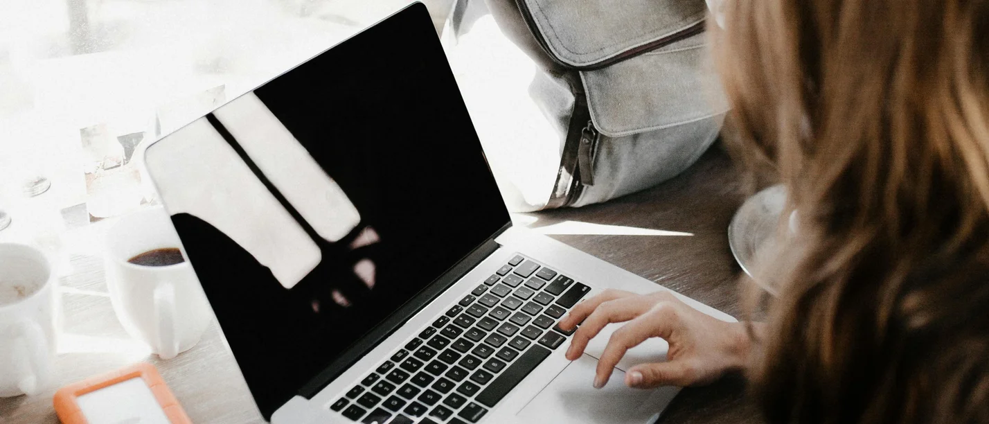Das Kompaktprogramm Unternehmenspraxis für NextGens gibt die Antworten, die angehende Unternehmer:innen, ihre Partner:innen und Young Professionals in Familienunternehmen suchen. (Foto: pexels | Andrew Neel) Blick über die Schulter einer Frau, die an einem Laptop sitzt.