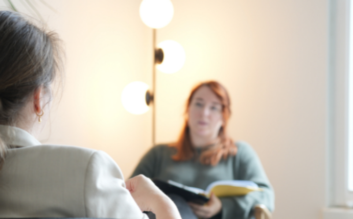 Ein Therapeutin und eine Patientin sitzen sich gegenüber.