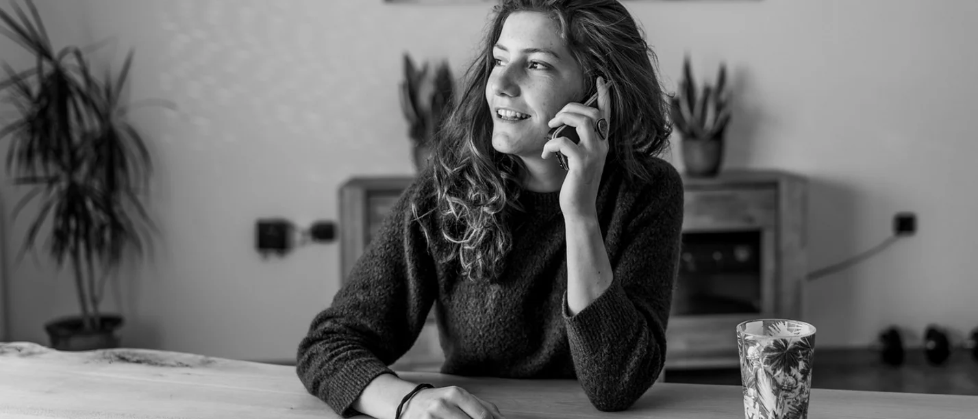 Zuhören fördert unsere Gesundheit. (Foto: pixabay | VinzentWeinbeer) Eine junge Frau sitzt an einem Tisch und telefoniert.