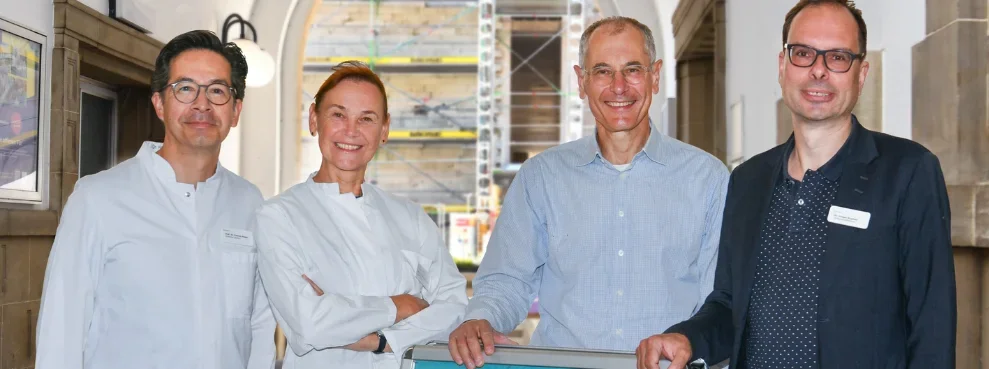 Four people smile into the camera.